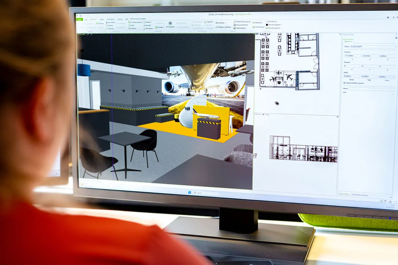 Frau sitzt vor Monitor. Auf dem Monitor wird eine 3D-Visualisierung einer Einrichtungsplanung gezeigt.