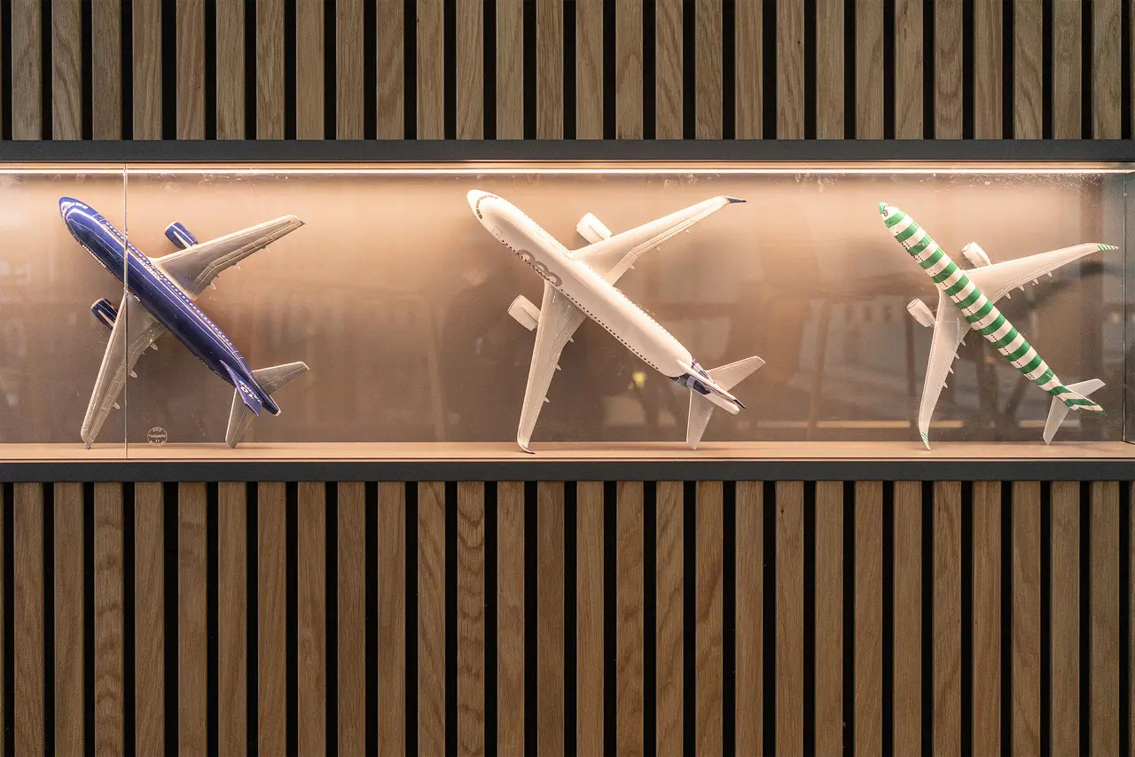 tischlerarbeit-empfangstresen-holzverkleidung-miniatur-flugzeuge